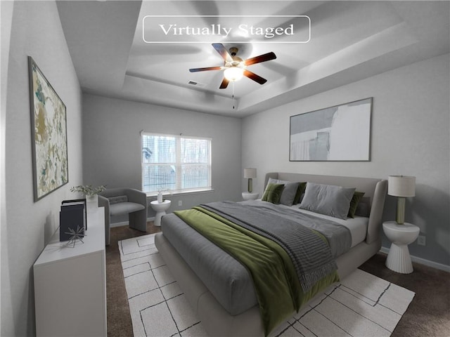 bedroom featuring a raised ceiling and ceiling fan