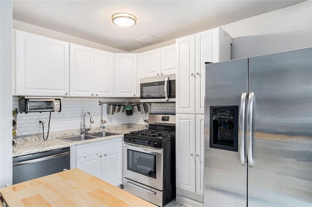 1705 Monroe Dr NE Unit E3, Atlanta, GA 30324 - kitchen featuring stainless steel appliances, white cabinetry, and backsplash
