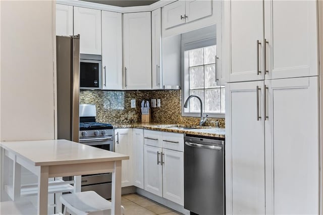 kitchen with white cabinetry, sink, backsplash, and appliances with stainless steel finishes