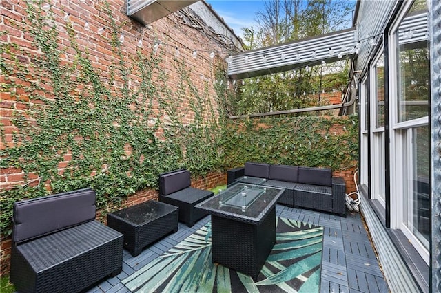 wooden deck featuring an outdoor living space with a fire pit