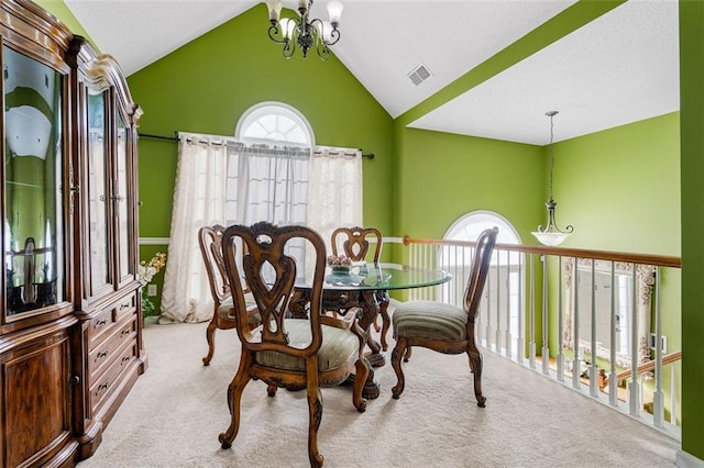 dining space with a chandelier, light colored carpet, and vaulted ceiling