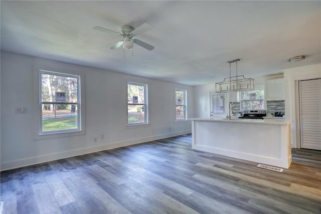 kitchen with white cabinets, pendant lighting, plenty of natural light, and sink