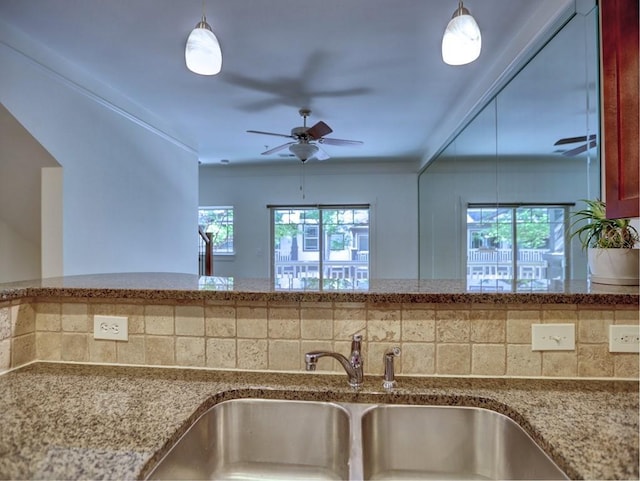 kitchen with ceiling fan, a healthy amount of sunlight, sink, and backsplash