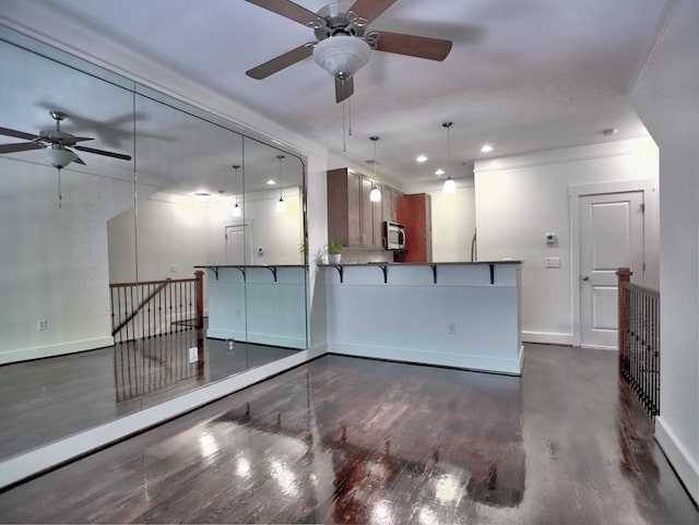 unfurnished living room with ceiling fan and dark wood-type flooring