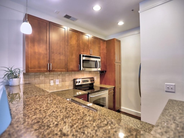 kitchen with backsplash, dark stone counters, sink, hanging light fixtures, and stainless steel appliances