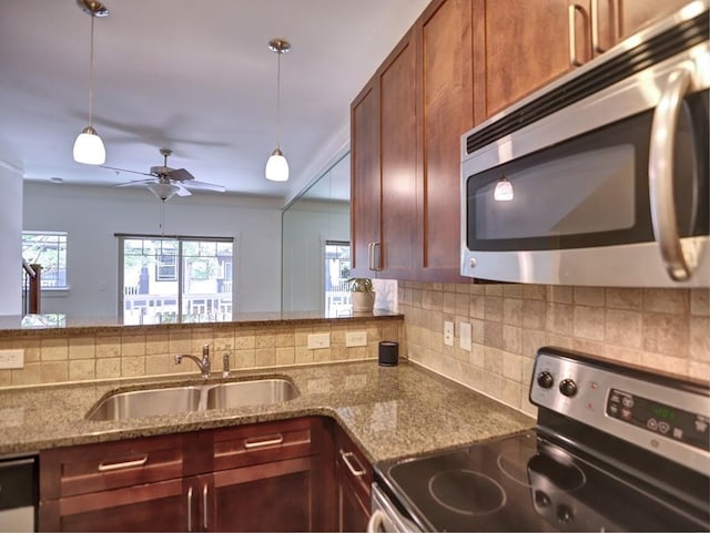 kitchen with appliances with stainless steel finishes, backsplash, ceiling fan, sink, and pendant lighting