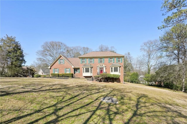 colonial-style house featuring a front yard