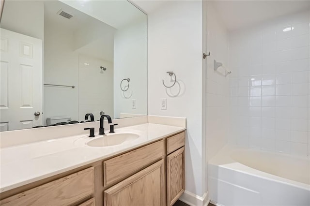 full bathroom featuring vanity, tiled shower / bath combo, and toilet