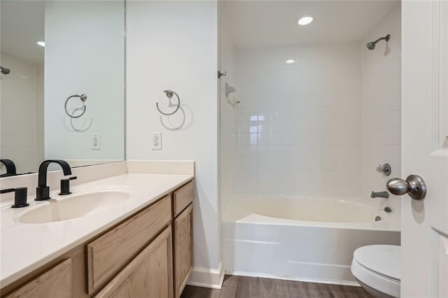 full bathroom with hardwood / wood-style flooring, tiled shower / bath combo, toilet, and vanity