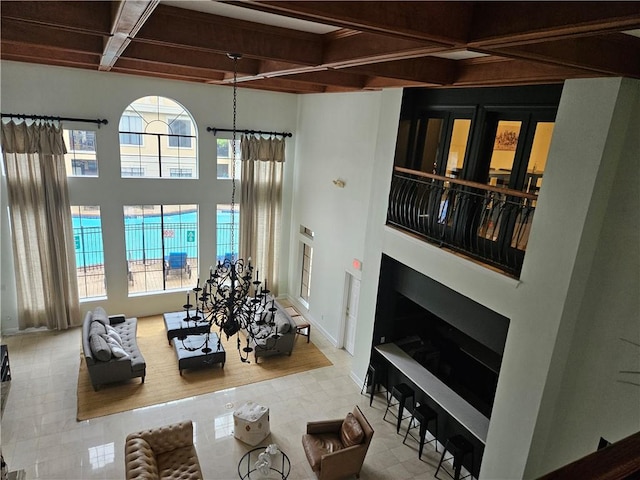 living room featuring plenty of natural light, beam ceiling, a towering ceiling, and coffered ceiling