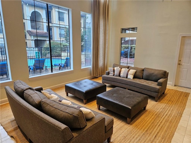 living room with a healthy amount of sunlight, light tile patterned flooring, and a high ceiling