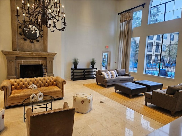 tiled living room featuring a large fireplace, a towering ceiling, and an inviting chandelier