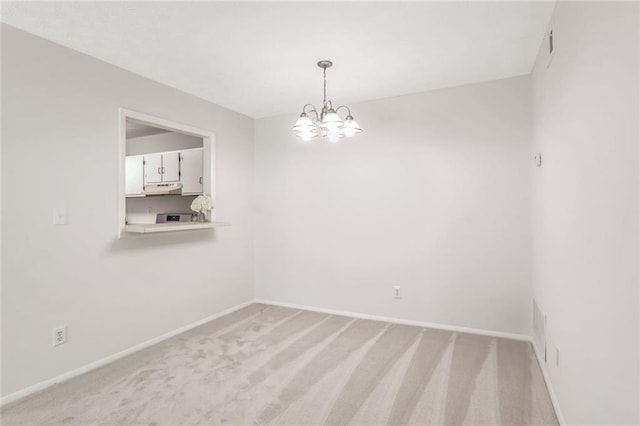 spare room with light colored carpet and a notable chandelier