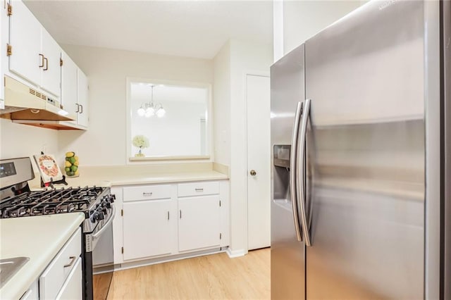 kitchen featuring white cabinetry, pendant lighting, light wood-type flooring, and appliances with stainless steel finishes