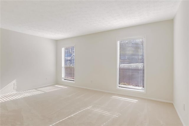 carpeted spare room with a textured ceiling