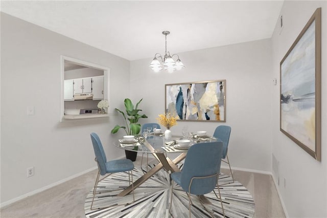 dining space featuring light colored carpet and a notable chandelier