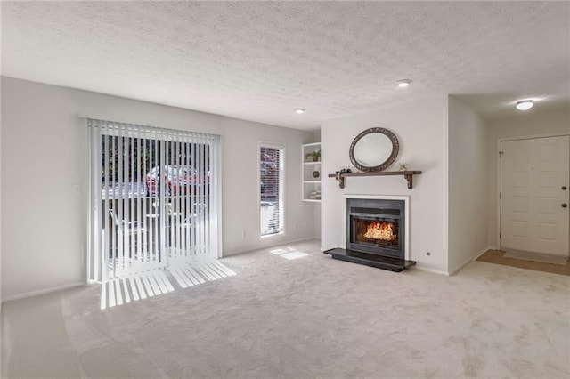 unfurnished living room with light carpet and a textured ceiling