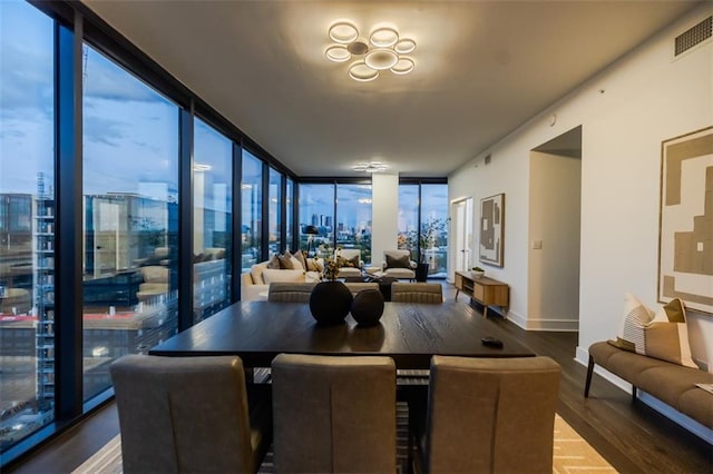 dining room with expansive windows, wood finished floors, visible vents, and baseboards