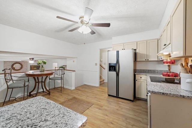 kitchen featuring ceiling fan, stainless steel refrigerator with ice dispenser, black electric stovetop, cream cabinets, and light wood-type flooring