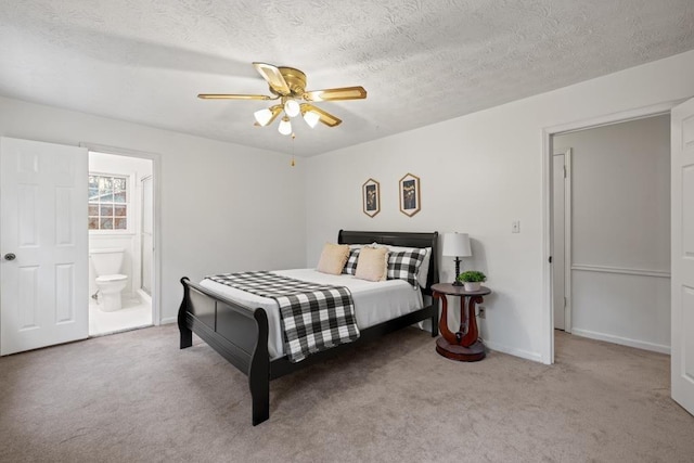 carpeted bedroom featuring ceiling fan, a textured ceiling, and ensuite bath