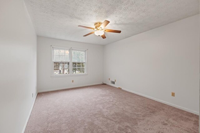 spare room with ceiling fan, carpet, and a textured ceiling