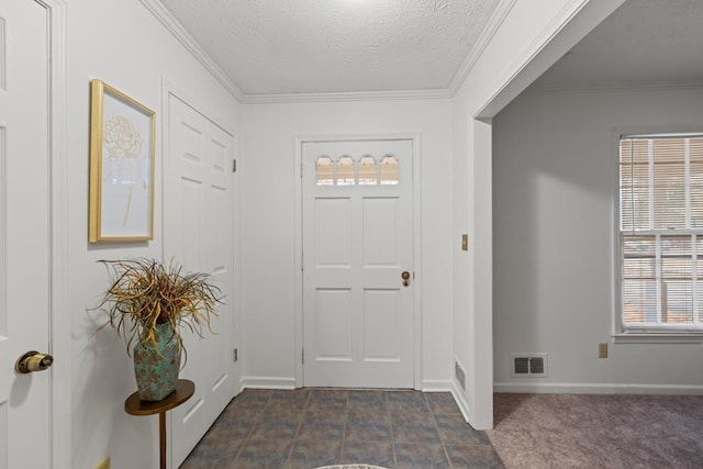 entrance foyer featuring crown molding, dark carpet, and a textured ceiling