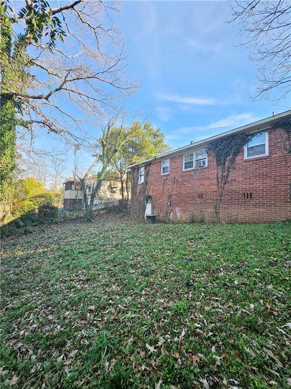 view of property exterior featuring crawl space, a yard, and brick siding