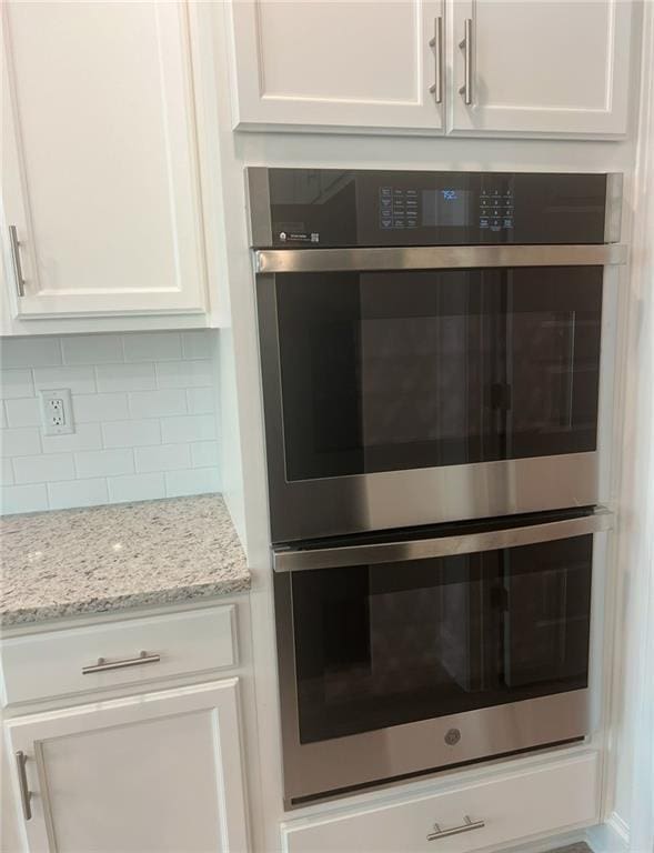 1023 Boulder Dr, Gray, GA 31032 - interior details with double oven, white cabinets, decorative backsplash, and light stone countertops