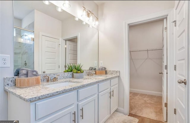 1023 Boulder Dr, Gray, GA 31032 - full bathroom featuring a sink, a walk in closet, double vanity, and a shower stall