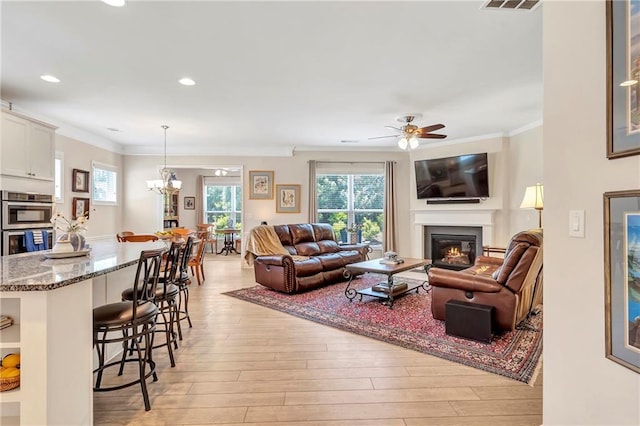 2920 Farmstead Way, Suwanee, GA 30024 - living area with ornamental molding, light wood-style flooring, a glass covered fireplace, ceiling fan, and recessed lighting