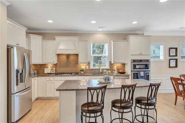2920 Farmstead Way, Suwanee, GA 30024 - kitchen featuring stainless steel appliances, a sink, premium range hood, light wood-type flooring, and crown molding