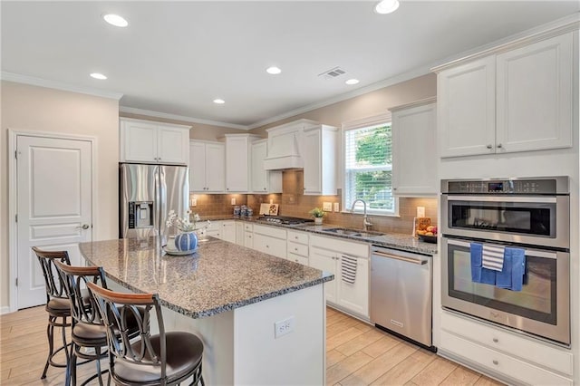 2920 Farmstead Way, Suwanee, GA 30024 - kitchen featuring stainless steel appliances, a sink, dark stone countertops, a kitchen breakfast bar, and light wood-style flooring