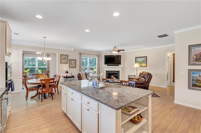 2920 Farmstead Way, Suwanee, GA 30024 - kitchen featuring a lit fireplace, crown molding, light wood finished floors, plenty of natural light, and recessed lighting