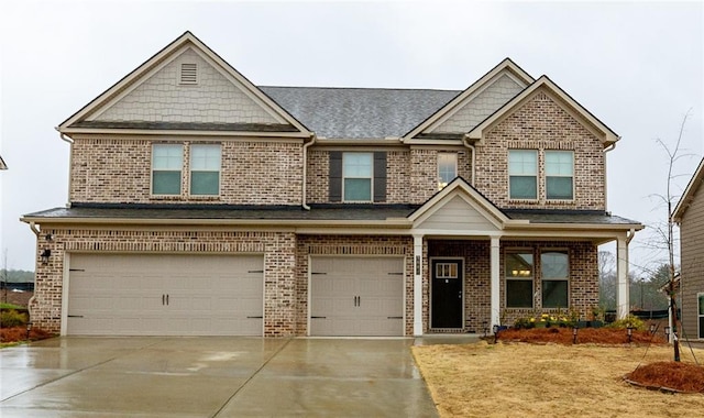 craftsman-style house with an attached garage, concrete driveway, and brick siding