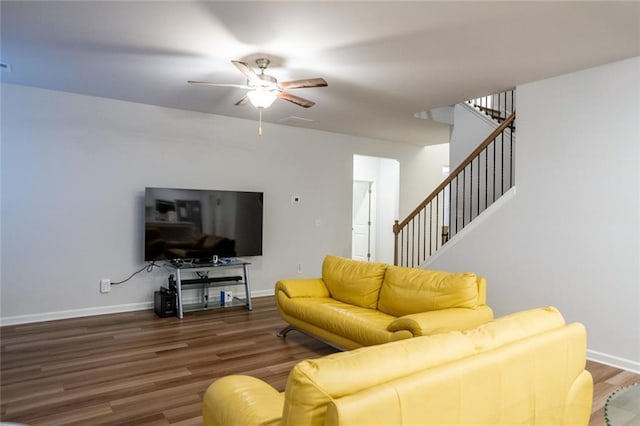 living area with baseboards, visible vents, ceiling fan, wood finished floors, and stairs