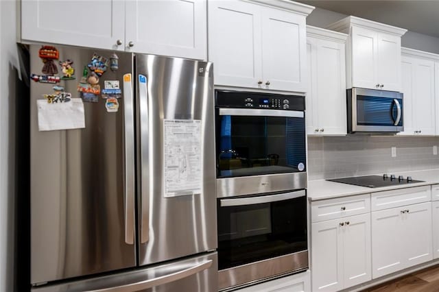 kitchen with stainless steel appliances, white cabinets, light countertops, dark wood-style floors, and tasteful backsplash