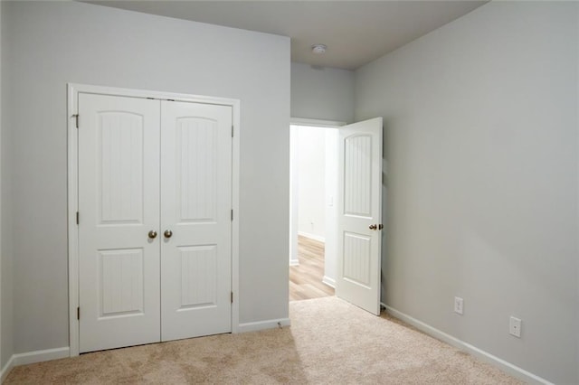 unfurnished bedroom featuring a closet, carpet flooring, and baseboards