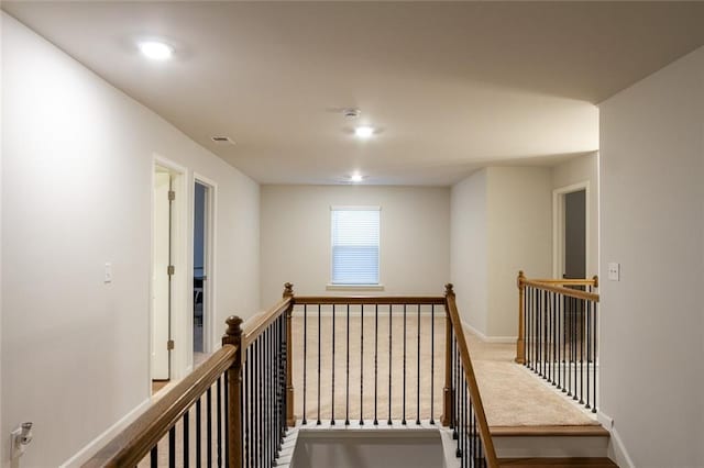 corridor with carpet, an upstairs landing, and baseboards