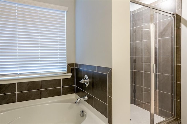 full bathroom with a shower stall and a bath