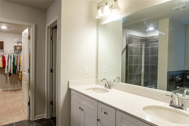 bathroom with double vanity, a stall shower, a sink, and visible vents