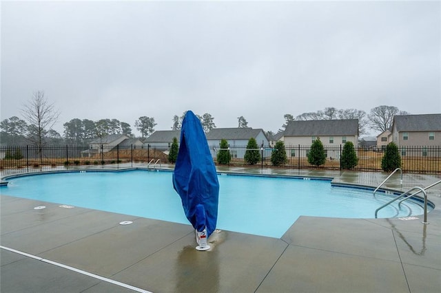 community pool with fence and a patio