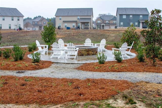 view of yard featuring a fire pit, a patio area, and a residential view