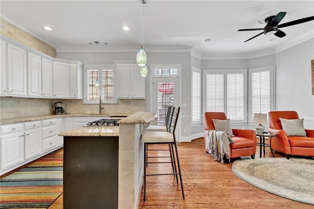kitchen with light wood finished floors, open floor plan, ceiling fan, recessed lighting, and white cabinets