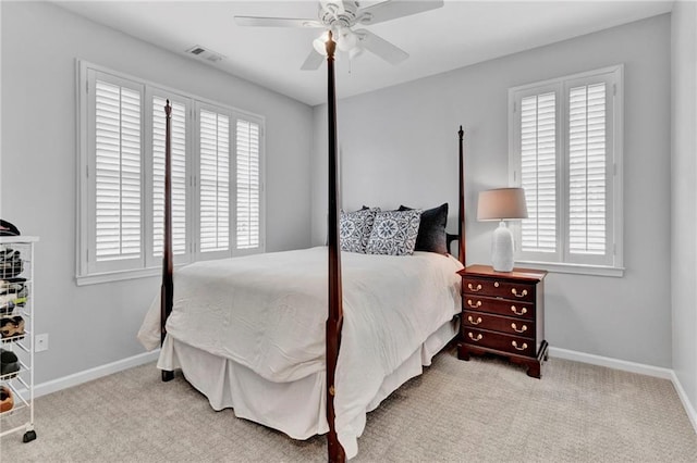 carpeted bedroom featuring multiple windows, baseboards, and a ceiling fan