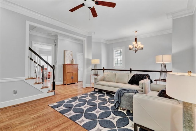 living area featuring ceiling fan, ornamental molding, wood finished floors, a chandelier, and baseboards