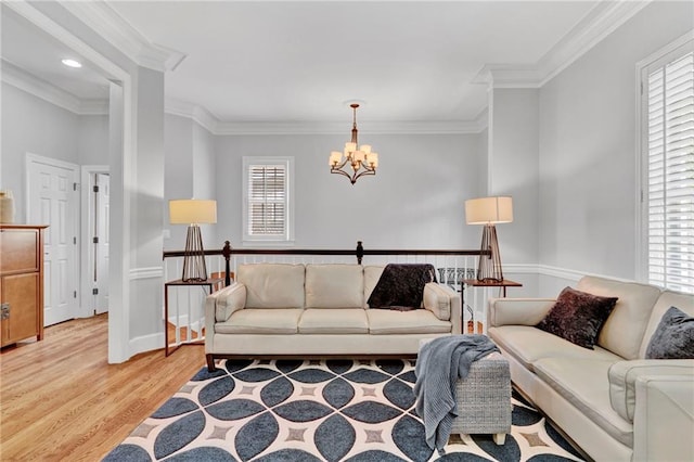 living room featuring a chandelier, light wood finished floors, and ornamental molding