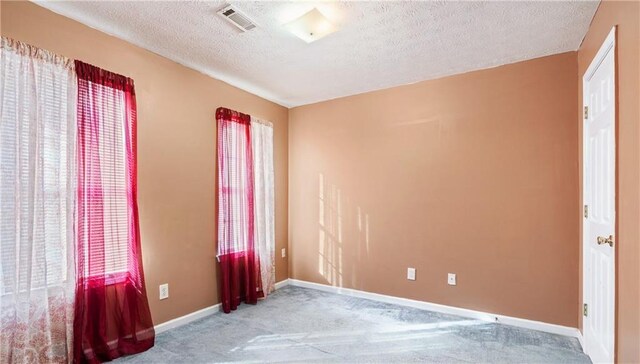 4014 Ivy Trace Ln, Ellenwood, GA 30294 - carpeted spare room with a textured ceiling, baseboards, and visible vents
