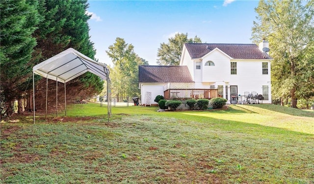 4014 Ivy Trace Ln, Ellenwood, GA 30294 - back of property with a wooden deck, a chimney, a detached carport, and a lawn