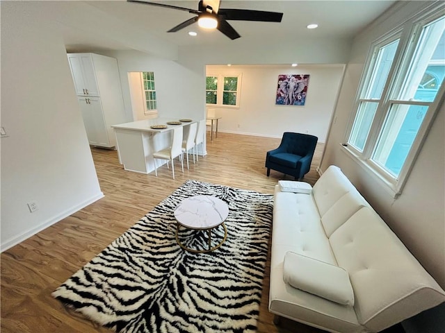 living area with recessed lighting, light wood-style flooring, baseboards, and ceiling fan