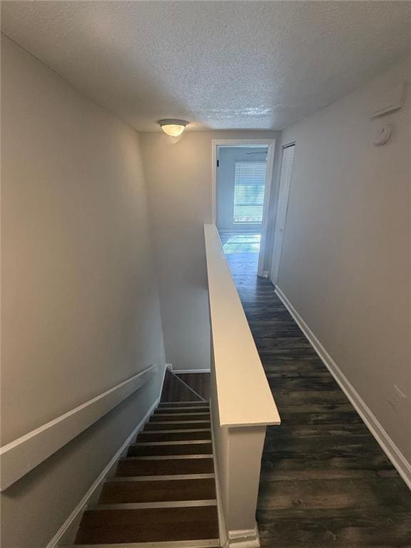 stairs with hardwood / wood-style flooring and a textured ceiling